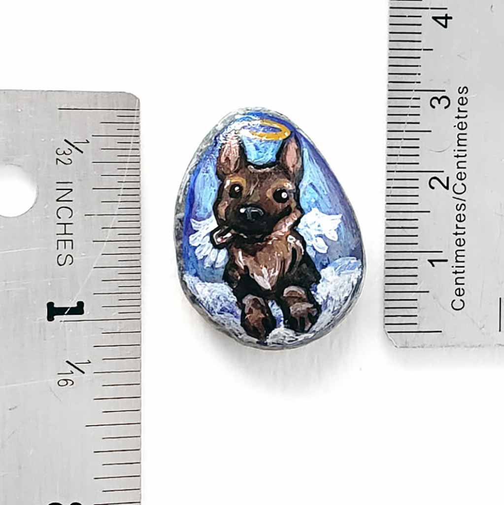 a small beach stone painted with dog art: a German Shepherd as an angel in the clouds. available as a stone keepsake or a pendant necklace