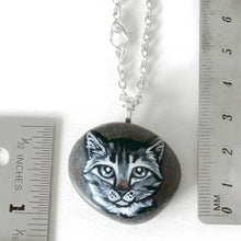 Load image into Gallery viewer, the grey tabby cat portrait stone, available as a necklace, next to two rulers to show its size: 1 5/16&quot; x 15/16&quot; or 3.4 cm x 2.3 cm and weighs approximately 12.5 grams or 0.44 ounces
