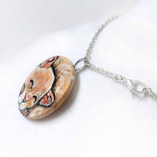 Load image into Gallery viewer, a smooth wood circle, hand painted with a sleeping hamster. available as a keepsake or pendant necklace
