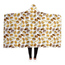 Load image into Gallery viewer, a woman wearing the Happy Cookies Hooded Blanket, featuring 10 illustrated smiling cookies patterned all over
