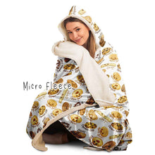 Load image into Gallery viewer, a woman wearing the Happy Cookies Hooded Blanket, featuring 10 illustrated smiling cookies patterned all over, lined with micro fleece
