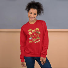 Load image into Gallery viewer, A woman is wearing the Happy Cookies Unisex Sweatshirt in the colour red, which features art of 10 different types of cookies with smiley faces
