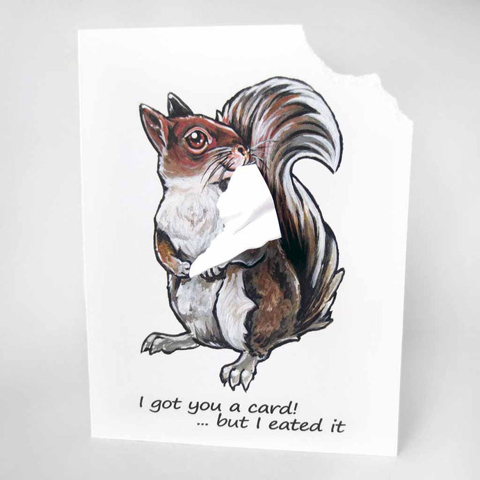 a greeting card featuring an illustration of a red squirrel. the right corner of the front of the card has been ripped off and is attached to the squirrel's mouth. the card reads, 