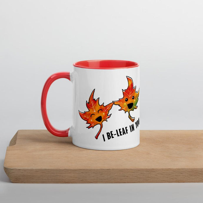 Ah 11 oz white ceramic mug with red handle and interior, printed on the front and back with art of two maple leaves, and the words, 