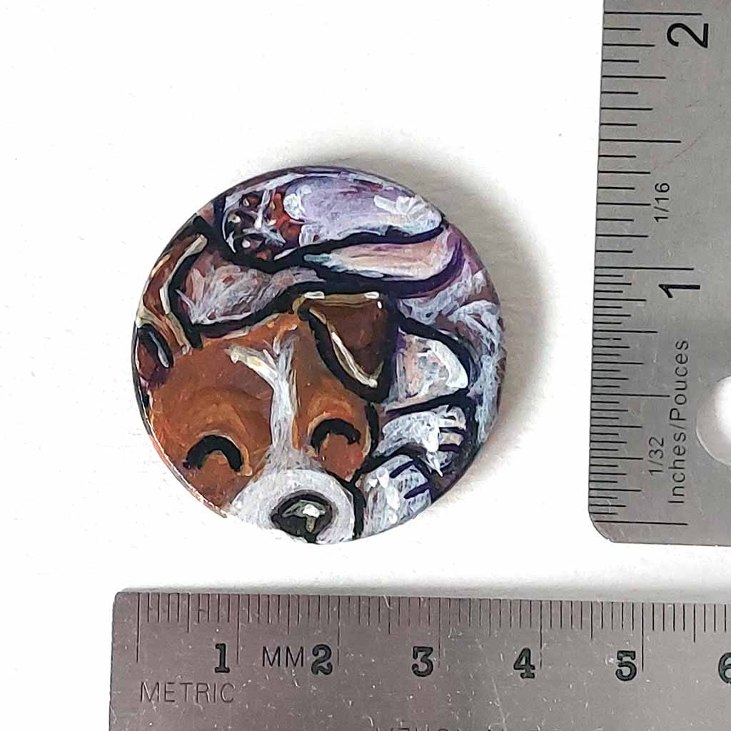 a small wood circle, hand painted with a jack russell terrier dog, curled up sleeping. available as a wood keepsake or pendant necklace