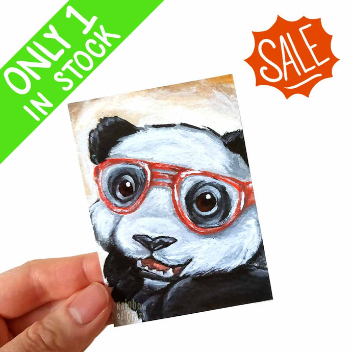 an aceo featuring art of a smiling panda bear wearing red glasses