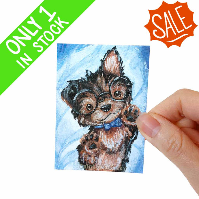 an aceo art print of a yorkshire terrier puppy wearing black glasses and a blue bow tie