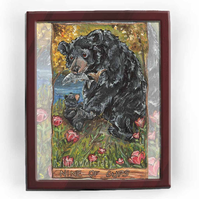 Art print of the nine of cups from the Animism tarot: a black bear holds a fish in her mouth, while her baby bear looks up eagerly. none wine cup flowers surround them.