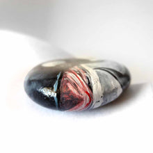 Load image into Gallery viewer, a round, flat beach stone is hand painted with art of an orca whale
