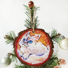 Load image into Gallery viewer, A wooden ornament with a painting of a white Ragamuffin cat with blue eyes, watching the snow fall
