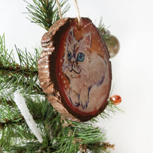 Load image into Gallery viewer, A wooden ornament with a painting of a white Ragamuffin cat with blue eyes, watching the snow fall
