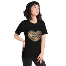 Load image into Gallery viewer, A woman wearing the Otters Love Premium Unisex T-Shirt in the colour heather black, which includes art of two otters forming the shape of a heart.
