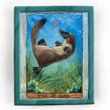 Load image into Gallery viewer,  an art print of the page of cups tarot card, from the animism tarot deck: a platypus swims in the ocean, playing with a purple lotus flower, with seaweed swaying below
