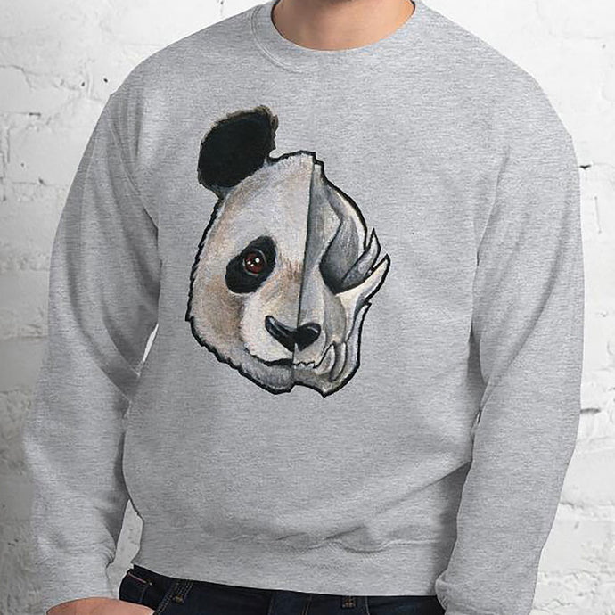 A man wears a unisex sweatshirt in the colour sport grey, printed with artwork of a split image: the left side features an panda's face, and the right side features an evil looking panda skull.