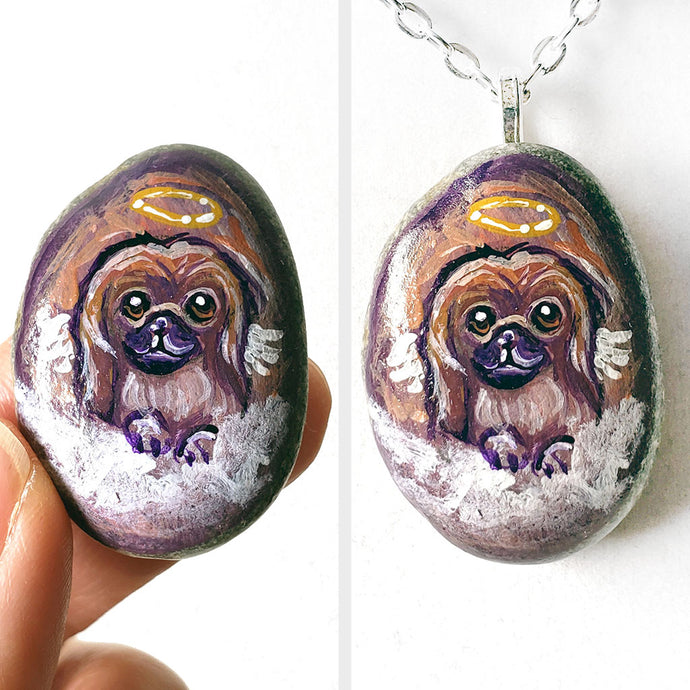 A portrait painting of a Pekingese dog as an angel with wings, painted on a small rock, available as a keepsake or pendant necklace