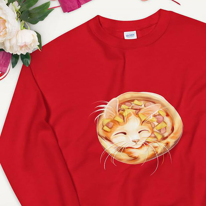 A unisex sweatshirt in the colour red, printed with art of an orange cat as a pineapple pizza, topped with pineapple and ham.
