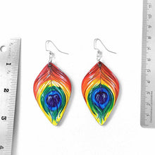 Load image into Gallery viewer, large, leaf shaped, wood fish hook earrings, hand painted with peacock feathers in rainbow colours
