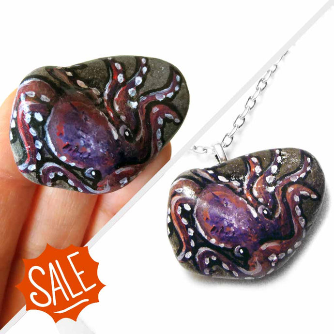 a purple and pink octopus painting on a small beach stone, available as a keepsake or pendant necklace
