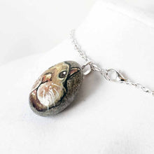 Load image into Gallery viewer, a small beach stone, hand painted with the fact of a creme d&#39;Argent rabbit, available as a keepsake or pendant necklace
