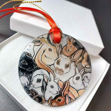 Load image into Gallery viewer, a round glass ornament, printed with a collage of different rabbit breeds, packaged in a flat white box
