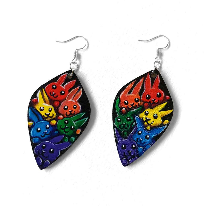 large leaf shaped wood earrings, hand painted with 6 rabbits in each colour of the rainbow, against a black background