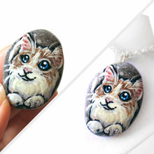 Load image into Gallery viewer, a beach stone, hand painted with a ragdoll cat, available as a rock art keepsake, or pendant necklace
