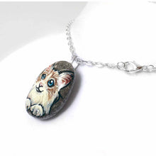 Load image into Gallery viewer, a beach stone, hand painted with a ragdoll cat, available as a rock art keepsake, or pendant necklace
