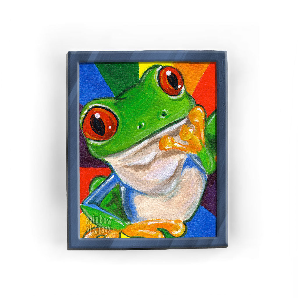 An art print featuring an illustration of a red eyed tree frog in front of a rainbow background