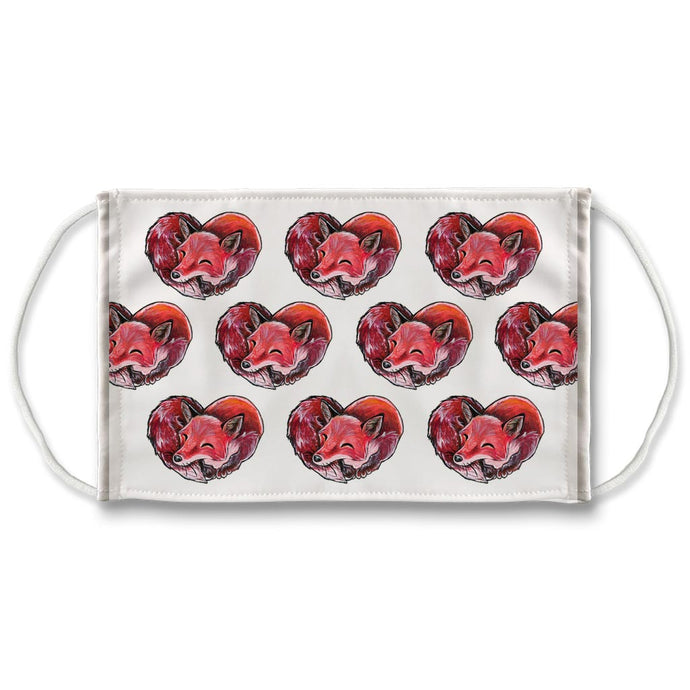 A white reusable face mask, patterned with little foxes sleeping in the shape of a heart.