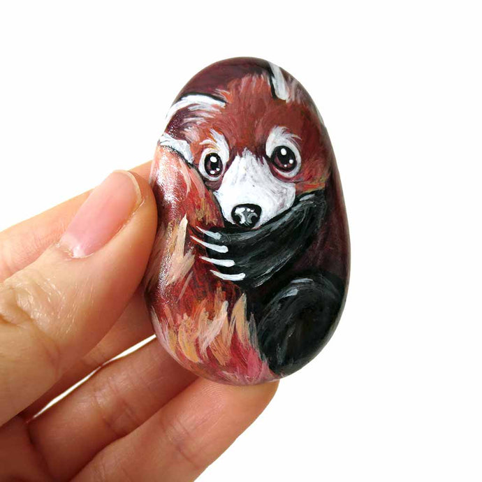 rock art, hand painted with a red panda hugging its tail