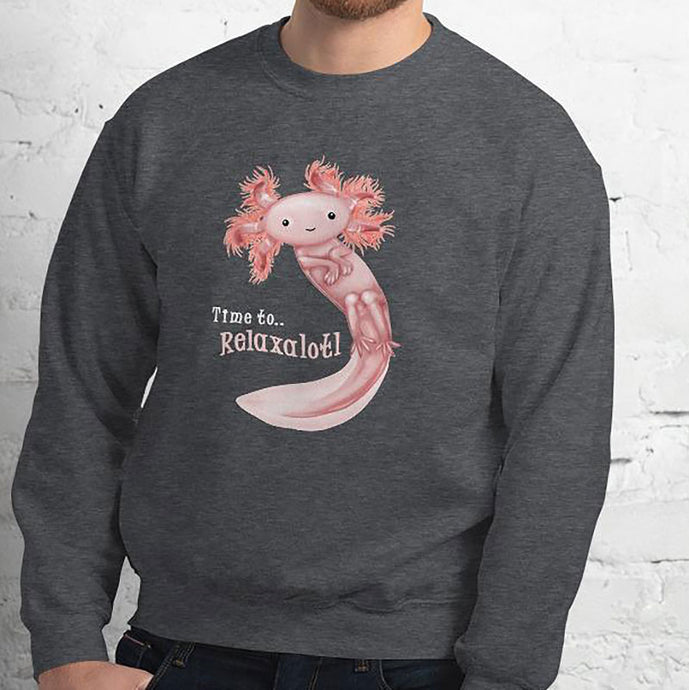 A man is wearing a unisex sweatshirt in the colour dark heather grey, featuring art of a pink axolotl, and reads, 
