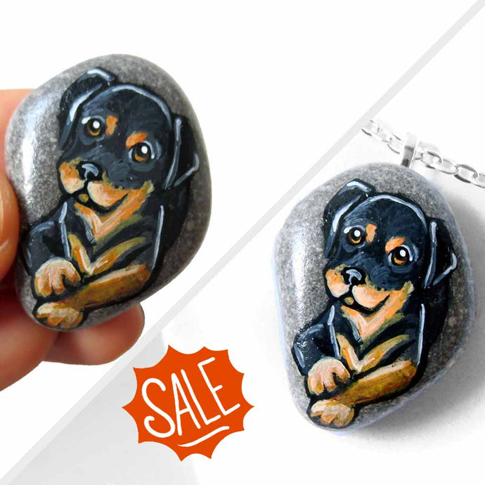small beach stone, hand painted with art of a rottweiler dog