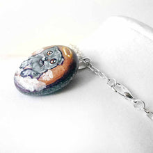 Load image into Gallery viewer, small beach stone, hand painted with a grey scottish fold cat as an angel in the clouds, available as a rock art keepsake or pendant necklace
