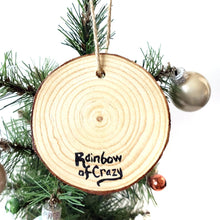 Load image into Gallery viewer, The back of a wood Christmas ornament, signed with, Rainbow of Crazy
