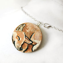 Load image into Gallery viewer, A circle wood disc painted with a portrait of a Shiba Inu dog having a nap, available as a keepsake or necklace
