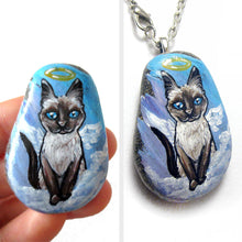 Load image into Gallery viewer, art of a siamese cat as an angel, is hand painted on a river rock, and is available as either a keepsake or a pendant necklace
