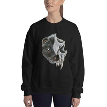 Load image into Gallery viewer, A woman wears a unisex sweatshirt in the colour black, printed with an image of a split portrait: the left side features the face of a skunk, and the right side features an evil looking skunk skull

