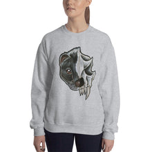 Load image into Gallery viewer, A woman wears a unisex sweatshirt in the colour sport grey, printed with an illustration of a split portrait: the left side features the face of a skunk, and the right side features an evil looking skunk skull

