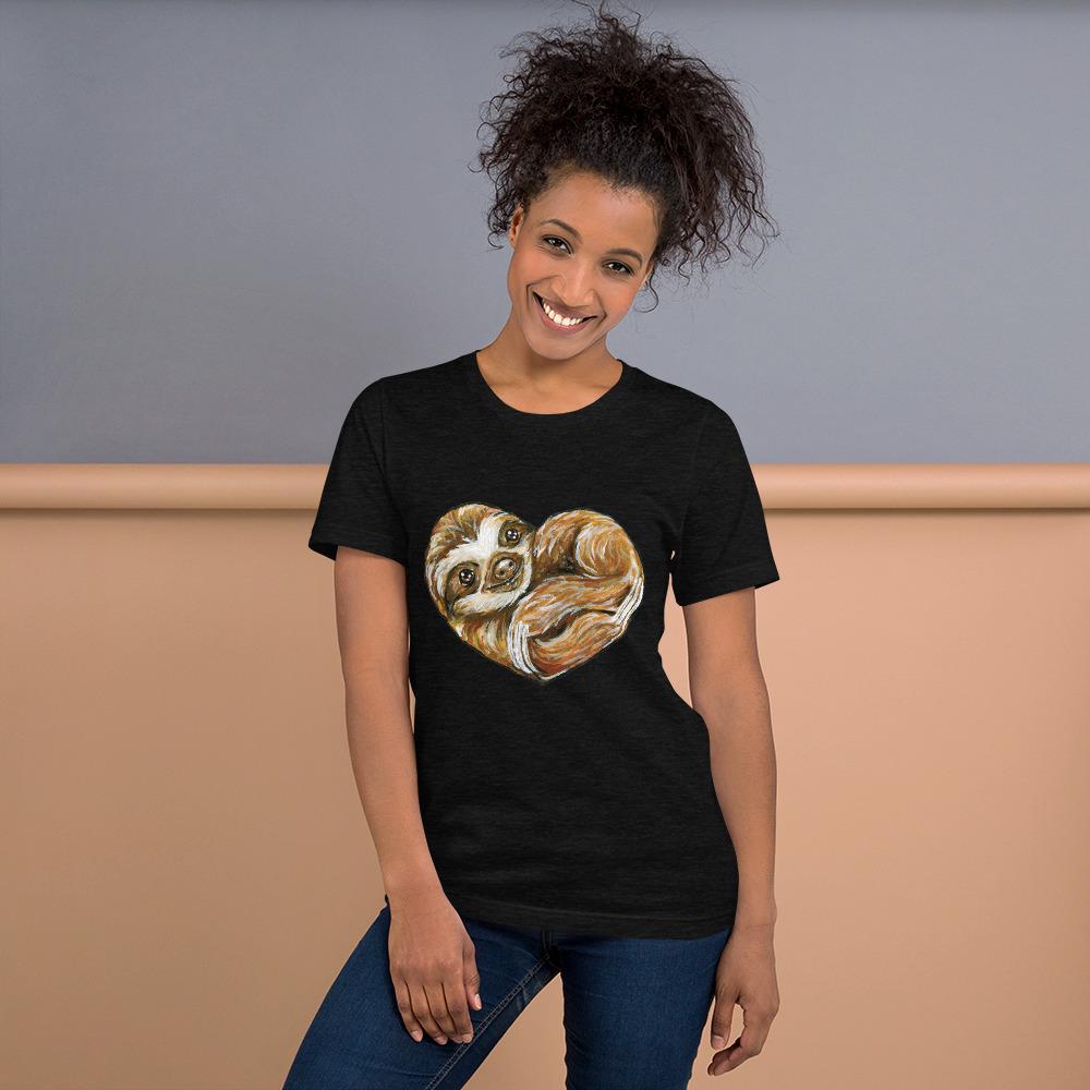 A woman is wearing the Sloth Love Unisex Premium T-Shirt in the colour black heather, which includes an illustration of a sloth forming the shape of a heart.