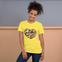 Load image into Gallery viewer, A woman is wearing the Sloth Love Unisex Premium T-Shirt in the colour yellow, which includes art of a sloth forming the shape of a heart.
