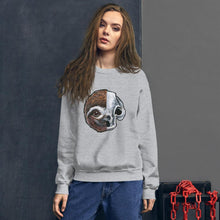 Load image into Gallery viewer, A woman wears a unisex sweatshirt in the colour sport grey, printed with a graphic of a split image: the left side features a sloth&#39;s face, and the right side features an evil looking sloth skull.
