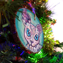 Load image into Gallery viewer, A handmade Christmas tree wood ornament, featuring a painting of a sphynx cat with blue eyes

