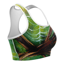 Load image into Gallery viewer, A sports bra printed with art of an orb weaver spider in front of its spider web.
