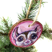 Load image into Gallery viewer, A wood Christmas tree ornament, hand painted with art of a sugar glider in front of a pink background.
