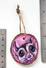 Load image into Gallery viewer, A wood Christmas tree ornament, hand painted with art of a sugar glider in front of a pink background.

