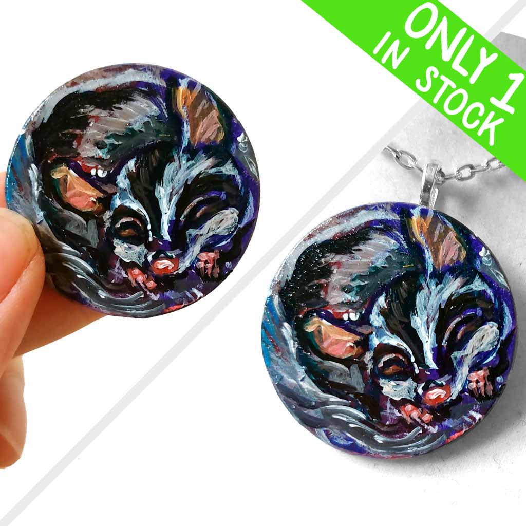A painting of a sleeping sugar glider, hand painted on a small, smooth, wood circle. Available as a keepsake art or pendant necklace