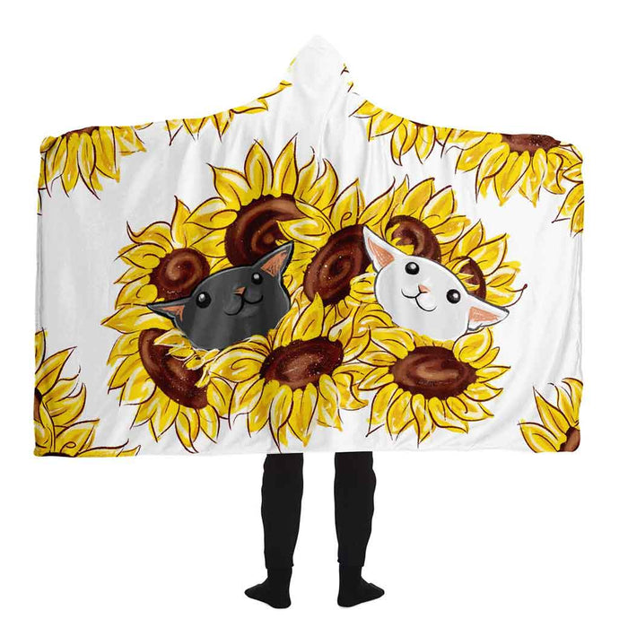 a man wears a white microfiber fleece hooded blanket, printed with sunflower art, with a black cat and white cat peeking out from the flowers