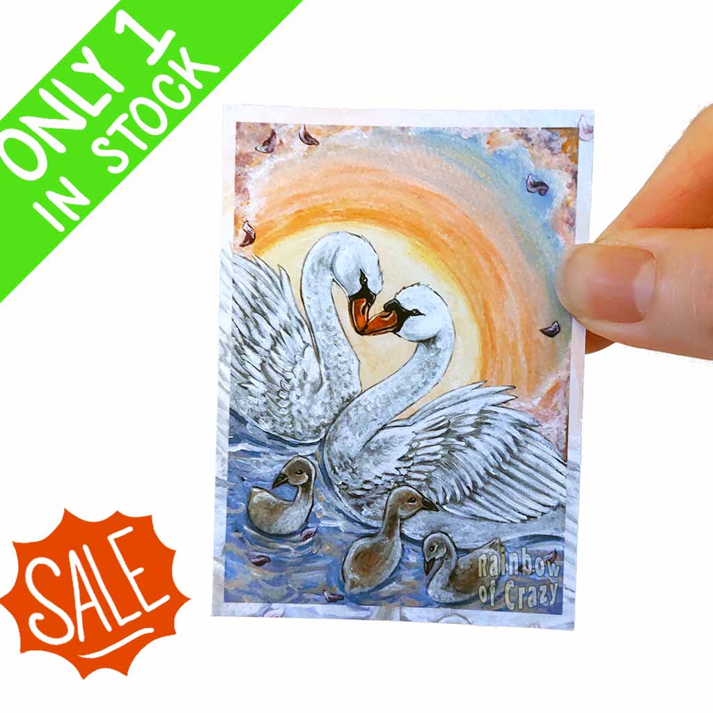 ACEO art print featuring the Ten of Cups card, from the Animism Tarot: two mute swans swim together with their three babies, while the sun sets behind them.