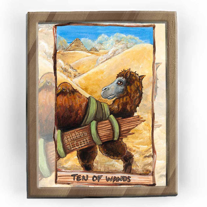 an art print of the ten of wands tarot card, from the animism tarot: a bactrian camel crosses the desert sands, wiith a load of sticks on its back, it looks over at the pyramids in the background