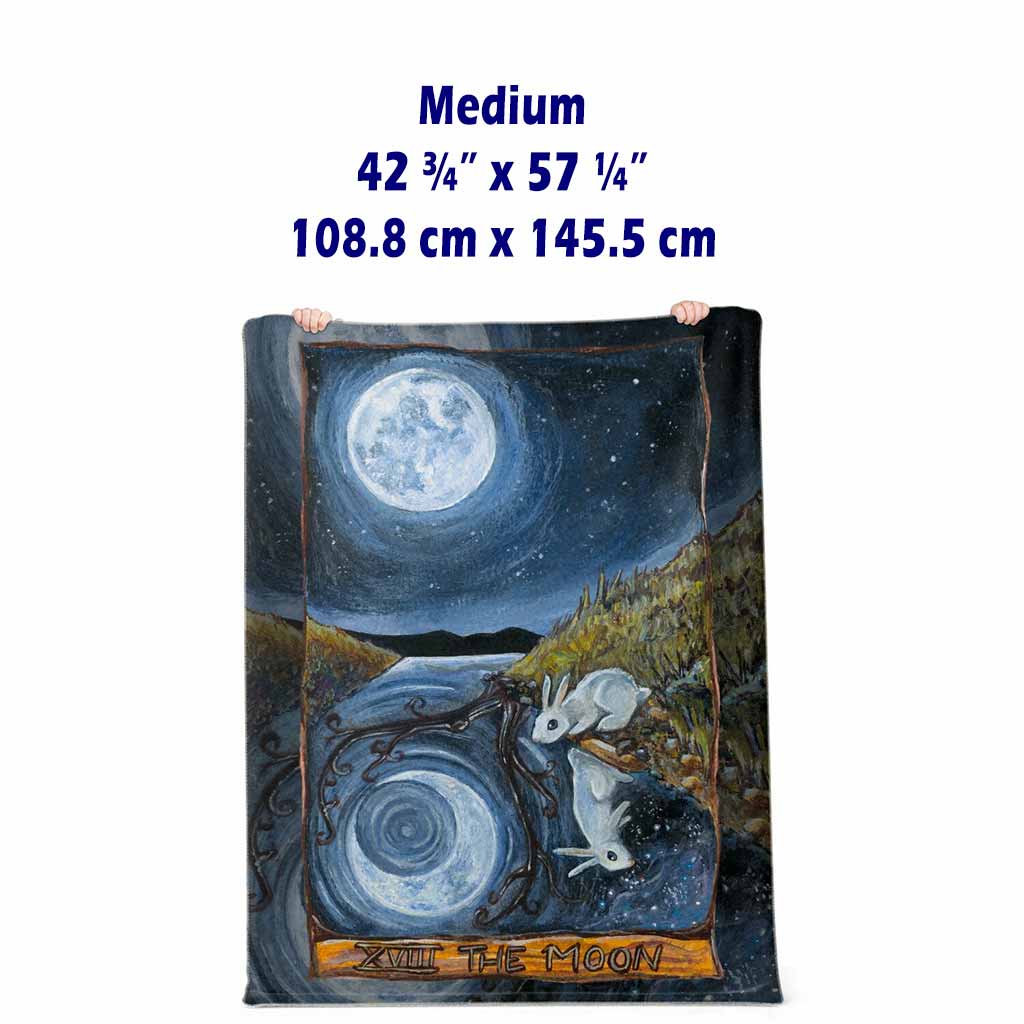 A micro-mink blanket lined with microfiber fleece, featuring a print of The Moon card, from The Animism Tarot: A white rabbit peers into a strange reflection in the water.. the moon and reflections shine differently